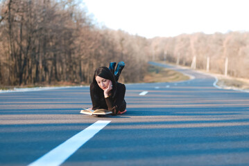 woman reading book on road