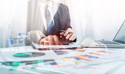 Businessman holding tablet and checking analyzing sales data growth graph chart and stock market on...