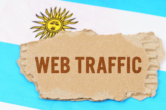 Against the background of the flag of Argentina lies cardboard with the inscription - Web Traffic - Powered by Adobe
