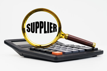 On a white background lies a calculator and a magnifying glass with the inscription - SUPPLIER