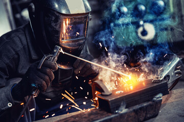 Closeup Industrial welder at factory use equipment mask and tool weld for metalwork with smoke,...