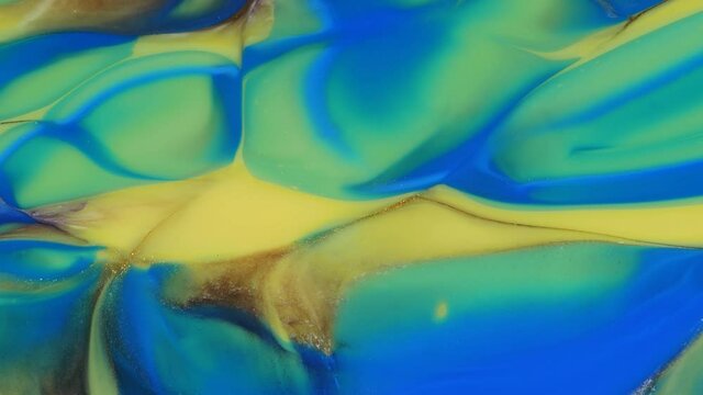 Blue, yellow, green, streaks on a colorful background. Abstract light pastel streams flow along the plane on a blue background. Marble texture. Fluid art. Liquid abstractions.