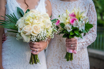 Lgbt lesbian women brides holding bouquets side by side - same sex wedding