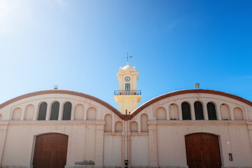 Warehouses and tower clock in Gandia's port (Valencia, Spain), in a sunny day
