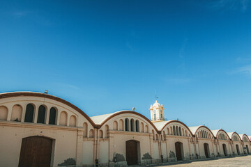 Warehouses and tower clock in Gandia's port (Valencia, Spain), in a sunny day