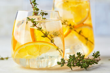 Refreshing cocktail with ice, orange and thyme. Refreshing summer homemade alcoholic or...