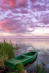 Beautiful landscape with boats on the lake and clouds in the sunset sky.