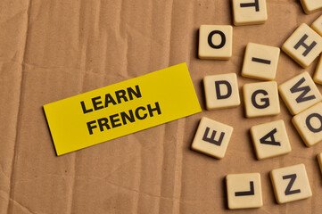 Top view of alphabet letters and memo note written with LEARN FRENCH. Education concept.