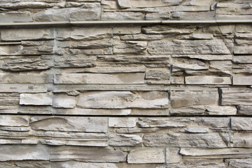 The wall of the house is masonry of yellow stone