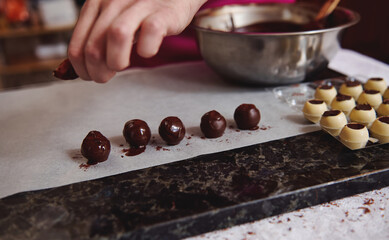 The final step in the preparation of Belgian chocolate truffles in the kitchen.