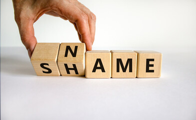 Name or shame symbol. Businessman turns wooden cubes and changes the word 'shame' to 'name' or vice...