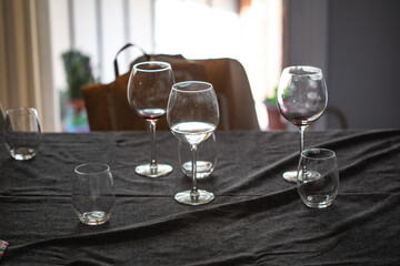 Empty wineglasses used after a party on a table with grey sheets