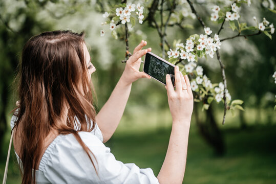 A girl with a phone in her hand takes pictures of selfies, photos for Internet
