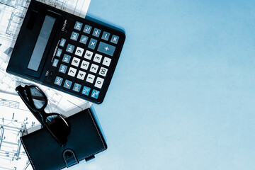 Calculator, notepad, black glasses on the working documentation top view on a light background with space for text. Business background template.
