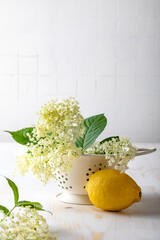 Preparing homemade elderflower lemonade with lemon, lime juice and freshly picked elderberry...