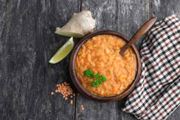 Vegan Red Lentil Soup in wooden bowl on rustic table