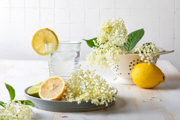 Glass of homemade elderflower lemonade with lemon, lime juice and freshly picked elderberry...