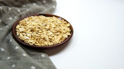 Oats in wooden bowl and scoop on white background. Top view, high resolution product. Healthy food Concept.