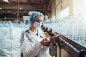 Female worker with protective face mask working in medical supplies research and production factory...