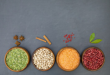 Mix of different leguminous plants and spices. Flat lay of various sources of vegetable protein: beans, lentils, peas, chickpeas, mung bean in bowls. Top view. Copy space. 