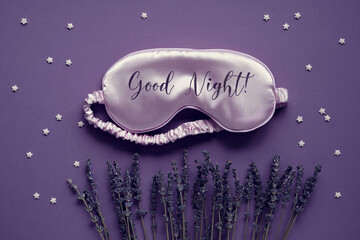 Sleep mask with dry lavender flowers on deep purple background with stars. Text Good night on the...