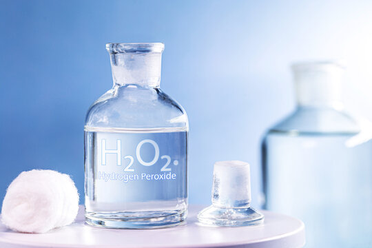 Glass of pure hydrogen peroxide, H2O2, with a piece of cotton on the side