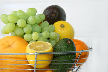Fruits in a vase oranges grapefruits, tangerines, lemons, avocados, grapes