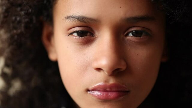 Hispanic child girl face looking at camera. Serious pre-teen latina