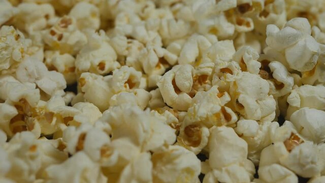 a lot of popcorn pours in. Close-up. Dolly.