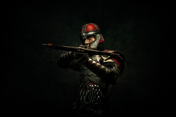 Portrait of a medieval fighter holding a crossbow in his hands - obrazy, fototapety, plakaty