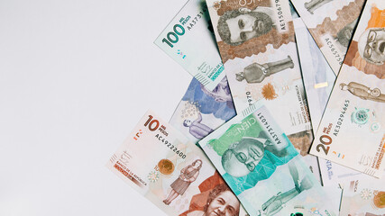 Colombian money of different denominations on white background