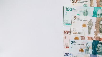 Colombian money of different denominations on white background