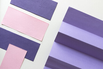 violet and light pink swatches of textured and pleated construction paper - photographed from above - blank space for text