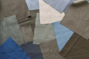 overlapping formal men's suit fabric swatches on white - photographed from above in flat lay composition