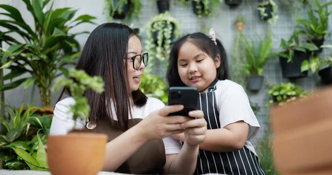 Mother and daughter take a picture plant.