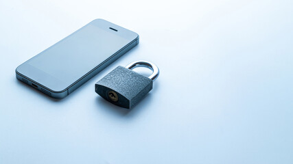 Business security protection. Modern space grey mobile phone with padlock, key on white background. Smartphone fraud, online scam and cyber security threat.