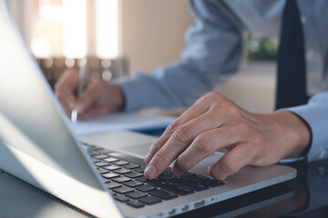 Businessman busy working on laptop computer and business document in office