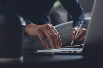 Man using stylus pen on digital tablet and working on laptop computer at home, work from home...
