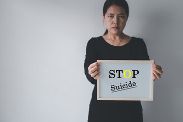 Against woman hands holding banner with stop suicide message,Mental health care concept - obrazy, fototapety, plakaty