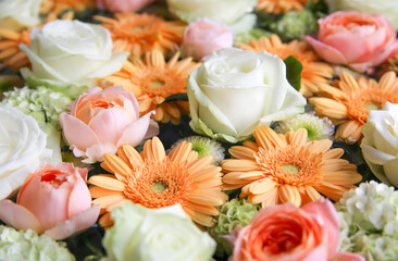 Roses, gerberas, and hydrangeas floating on the water. Pastel colored flowers.
