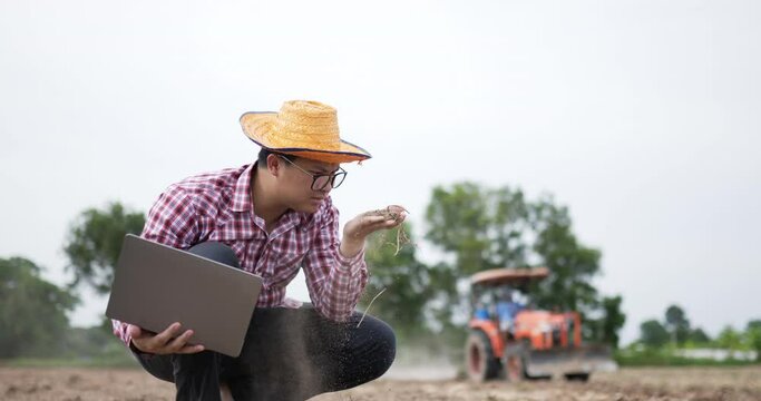 Smart farmer man cheking a soil with laptop