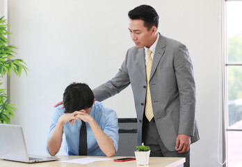 Senior Asain businessman soothing young employee who feeling stressed and upset from his work - obrazy, fototapety, plakaty