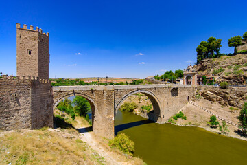 Obraz premium Puente de Alcántara, a Roman arch bridge across the Tagus River in Toledo, Spain