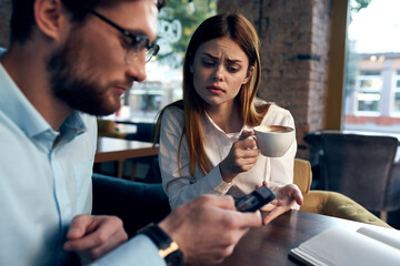 business men and women sit at the table with the phone chatting breakfast