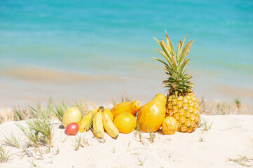 Tropical Fruits at the beach under blue sky, Pineapple, Papaya, Passion Fruits, Banana, Orange