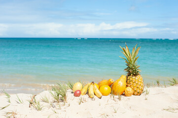 Tropical Fruits at the beach under blue sky, Pineapple, Papaya, Passion Fruits, Banana, Orange