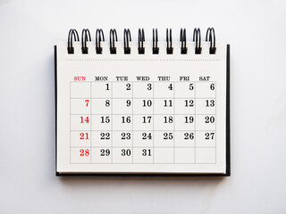 Blank notepad sheet and calendar for your congratulatory message. Closeup, top view. No people....