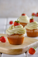 Tasty and fragrant cupcakes with strawberries and gentle cream on a white background