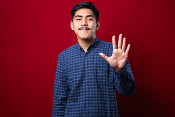 Handsome young man wearing casual clothes showing and pointing up with fingers number five while smiling confident and happy