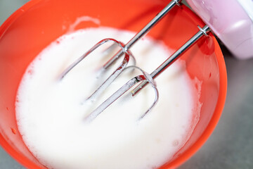 生クリームをミキサーで泡立てている写真。